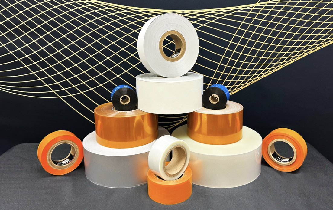 A variety of adhesive tape rolls in different colors and sizes are stacked on a surface, with a black and gold abstract geometric pattern in the background.