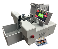 A compact, gray electronic key cutting machine with a digital touch screen displaying START, a tray for keys, and a set of colored key blanks placed nearby.